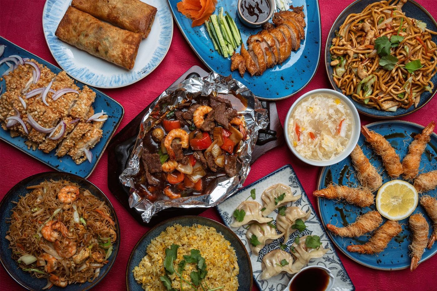 Mesa cheia de pratos chineses do Hua Xin